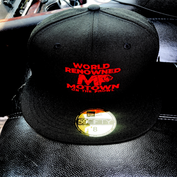 Black cap with red text and a gold sticker on the brim.