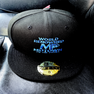 Black baseball cap with blue and white embroidered text.